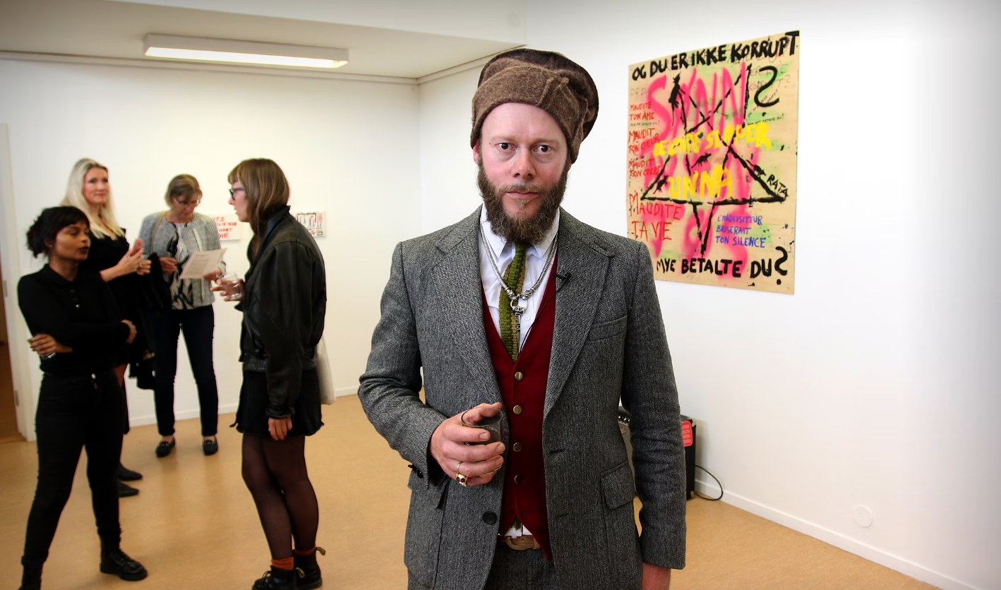 Cornelius Jakhelln på åpningen 5. juni 2020, med pentagrammet på veggen bak. I bakgrunnen står blant andre Marit Faanes, som holder arket, o